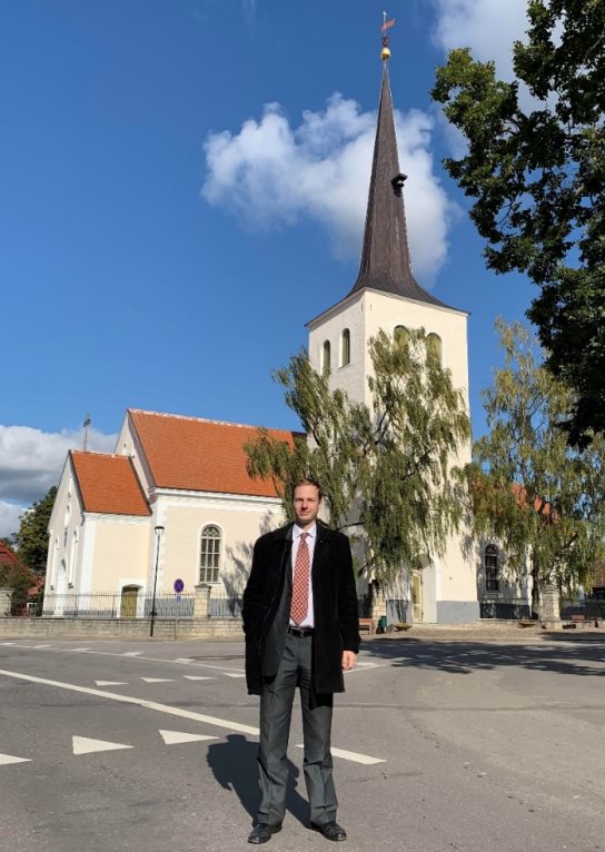 Автор настоящего исследования Сергей Александрович Тамби в городе, носящем неофициальное название «Сердце Эстонии». Именно с этим городом Дора Тамби связала свою вторую половину жизни. Эстонская Республика, город Пайде, лютеранская церковь Святого Креста, 22 сентября 2019 года. Источник: фотография из личного архива С. А. Тамби