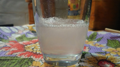 Стакан воды с маслом после добавления туда моющего средства(мыло)